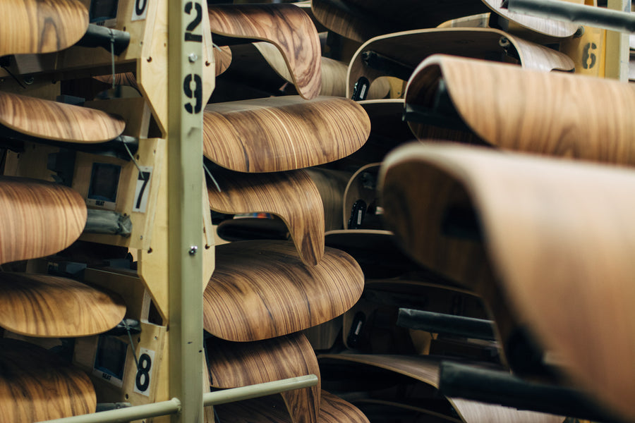Stacks of bent plywood shelves on a drying rack.