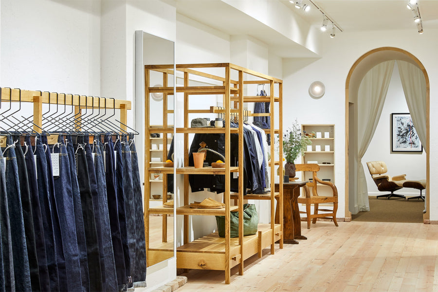 Clothing racks complemented by foliage and a decorative archway.