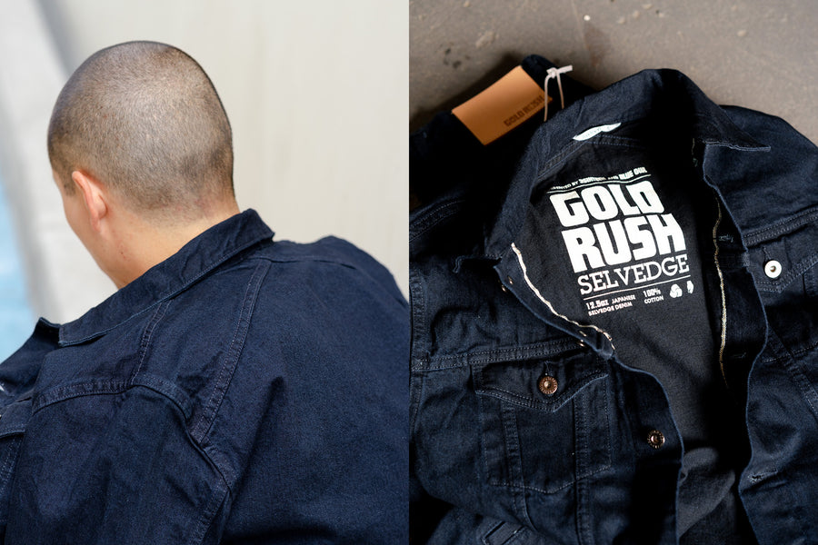 The back yoke of the jacket has a crossed detail, and there is a white silkscreen print on the inside of the jacket.
