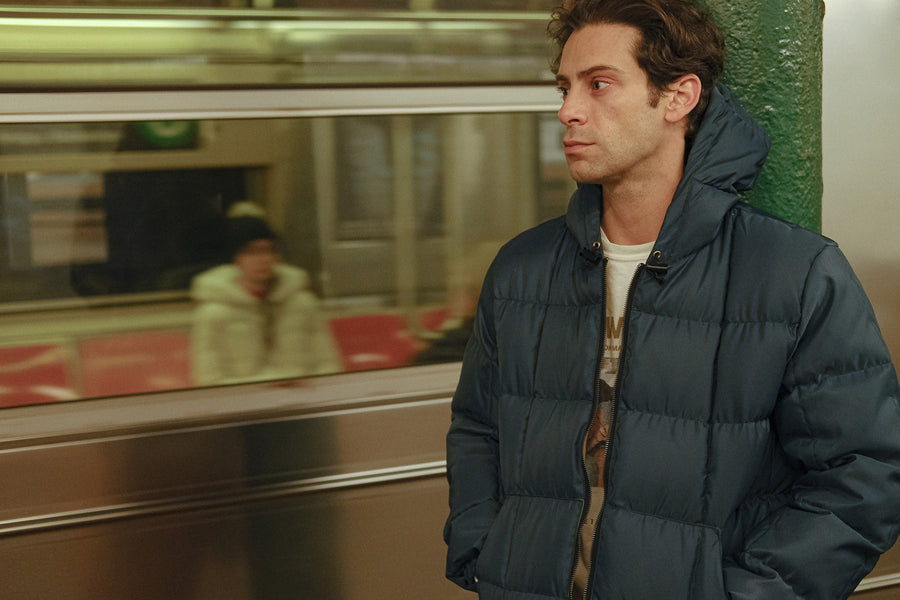 A photo of a man in a down jacket in the subway